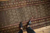 Village weave distressed Kurdish runner with staggered boteh motifs, heavy abrashes, and geometric borders.