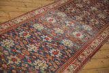 Low-angle view of the vintage Malayer runner's repeating henna pattern in sapphire and ruby.