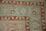 Corner of distressed vintage Tabriz carpet, terracotta Herati border on a slate blue field.