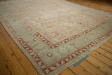 Distressed vintage Tabriz rug detail: faded rose field, slate blue Herati border, mostly even wear.