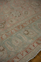 Distressed vintage Tabriz carpet showing faded rose, slate blue, and terracotta floral designs.
