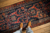 Personal view of a vintage Malayer runner's geometric animal and fish motifs in navy, rust, and green.