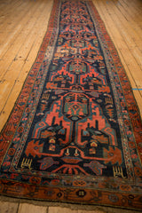 Long view of a vintage Malayer runner showing its contoured shape and repeating geometric motifs.