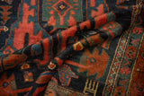 Rich texture of a Malayer rug's short pile, showing navy, rust, and mallard green geometric motifs.