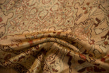 Folded antique Karabagh rug displays its distressed pile in soft apricot and muted blue.