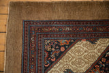 Detail of the antique Serab rug's wide camel border and intricate Herati design motifs.