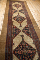 Antique Serab runner showing intricate Herati motifs within a navy diamond medallion and patterned camel field.