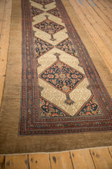 Fringed end of an antique Persian Serab runner, showing camel ground and intact side cords.