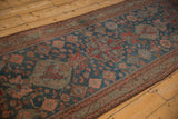 Vintage distressed Malayer runner with stepped medallion, floral motifs, and subdued jewel tones.