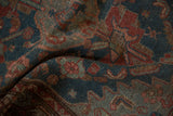 Distressed Malayer runner's folded texture revealing dusty sapphire and cherry red floral designs.