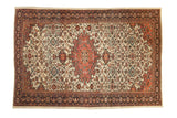 Antique Farahan Sarouk carpet with a blush medallion, ivory field with dense florals, and a dark navy blue border.