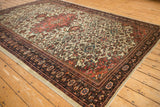 Traditional floral patterns on an antique Farahan Sarouk carpet, captured from a full, angled perspective.
