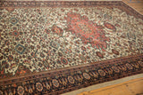 Perspective view of an antique Farahan Sarouk's blush medallion, dense floral field, and navy border.