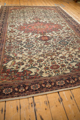 Angled perspective of an antique Farahan Sarouk carpet highlighting its low pile and intricate floral field.