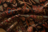 Lush, hand-knotted wool pile showing scrolled vines and blossoms in sapphire and burgundy on a charcoal field.
