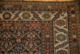 Corner view of an antique Malayer runner's intricate serrated leaf and serpent motif borders.