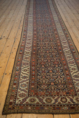 Angled perspective of an antique Malayer runner, highlighting its long form and intricate trellis pattern.