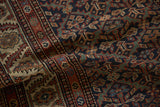 Close detail of the serrated leaf trellis and serpent border on a hand-knotted antique Malayer rug.
