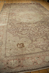 A long perspective view down the field of a distressed vintage Kayseri carpet with muted floral vines.