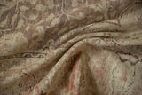 The time-softened, low pile texture of a distressed Kayseri carpet shown in soft folds.
