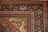 Corner detail of a vintage Mahal rug showing the Samovar cross-section border in brick red and navy blue.
