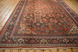 A vintage Mahal carpet viewed from an angle, emphasizing the complex Samovar border against the Herati field.