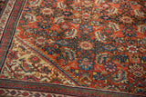 Angled close-up of a vintage Mahal carpet's brick red Herati field and Samovar border.