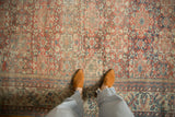 Distressed Mahal rug, faded ruby, ivory, dusty blue, with floral and gul medallion patterns.