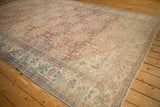Distressed vintage Mahal rug with visible foundation wear, faded floral medallions, ruby and blue tones.