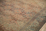 Distressed Mahal carpet's worn pile, featuring muted red, blue, and ivory floral patterns and border.