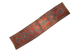 Antique Heriz rug runner with interconnected blue turtle medallions on a vibrant madder red ground.