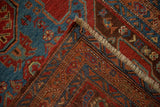 The dense, hand-knotted foundation of an antique Persian Heriz rug shown with a corner folded back.
