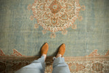 A perspective view of the distressed low-pile texture on a vintage Persian Meshed carpet.