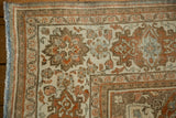 Corner of a vintage Persian carpet showing abrashed terracotta and brown floral motifs and low-pile texture.
