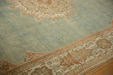 Low-pile texture of the abrashed dusty blue field beside the terracotta floral border.