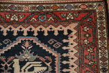 Intricate corner detail of an antique Malayer rug showing the madder red meandering vine border.