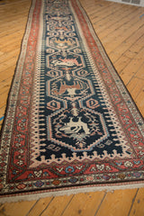 Angled perspective showing the full length of the antique Malayer runner and its column of pictorial medallions.