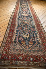Angled perspective of an antique Malayer runner with a column of stylized pictorial medallions.