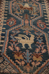 Close-up of pictorial medallions showing a stylized bird and horseman on an antique Malayer runner.