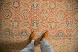 Mostly even wear on the low pile of a distressed Kashan carpet with faded brick red and blue arabesques.
