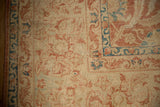 Corner detail of a distressed Kashan rug showing mostly even wear to the knot heads and a bound edge.