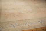 Distressed texture with faded beige, sand, and seafoam floral motifs on a vintage Tabriz carpet.