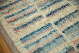 Plush shaggy pile with abstract blue and rose stripes alongside the original side cord selvage.