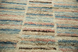 The shaggy hand-knotted pile shows abstract stripes in dusty rose, powder blue, and ivory.