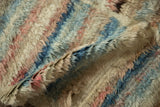 Soft, shaggy wool pile of an Afghani carpet with blended ivory, blue, and dusty rose hues.