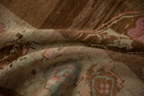 Distressed vintage Oushak rug texture with muted brown, pink, and blue tones, softly worn pile.