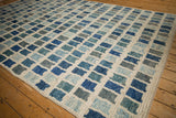 Modern Afghani hand-knotted carpet with abstract geometric blocks in ivory, blue, and silver tones.