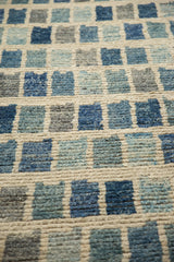 Textured blue, gray, and ivory abstract geometric pile on the Afghani modern carpet.