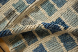 Hand-knotted pile of modern Afghani rug, abstract geometric ivory, blues, and silver.