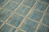 Hand-knotted modern Afghani carpet pile with ivory geometric grid and blue striations.